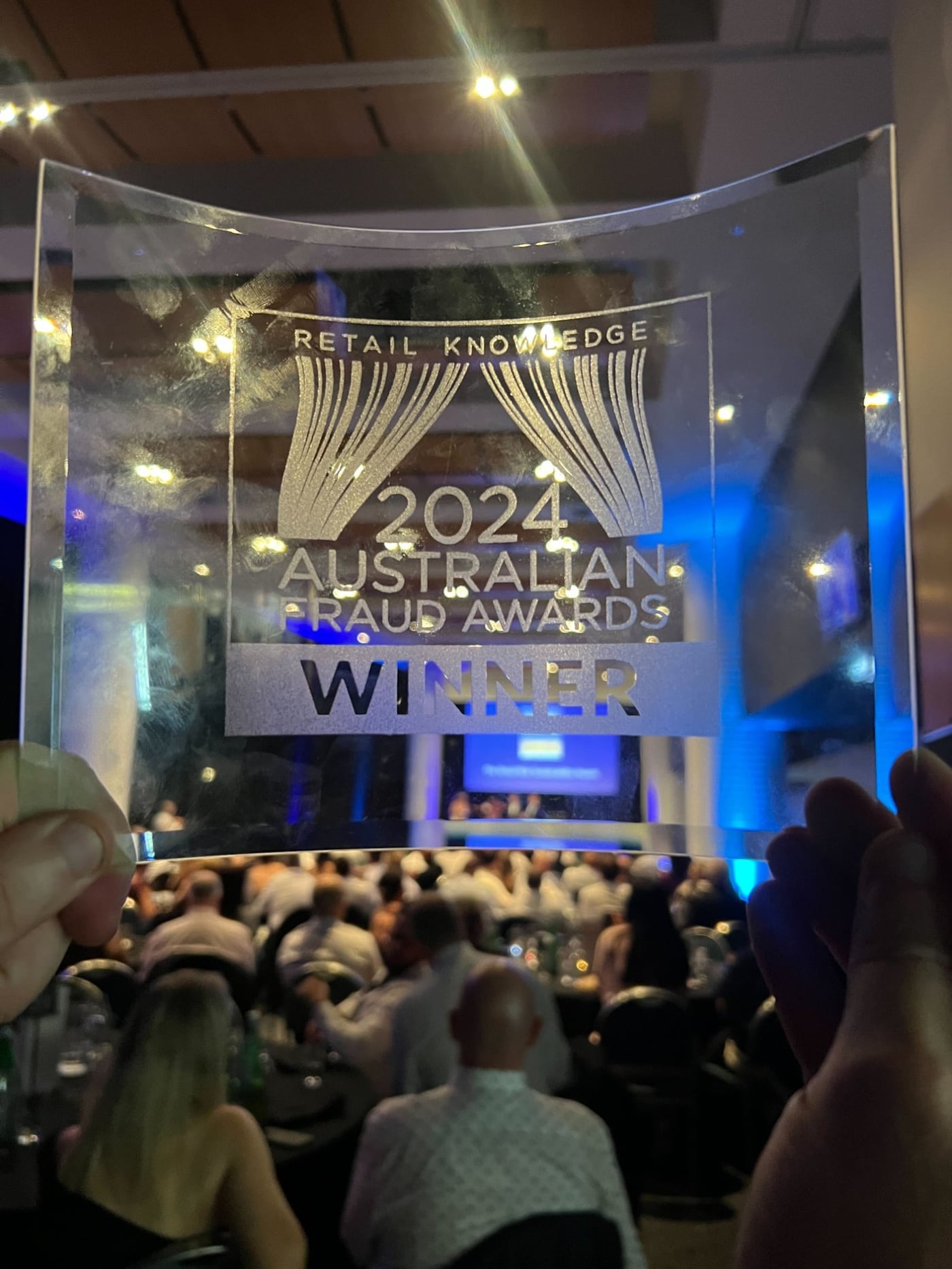 The 2024 Australian Fraud Awards winner trophy held up at the awards ceremony