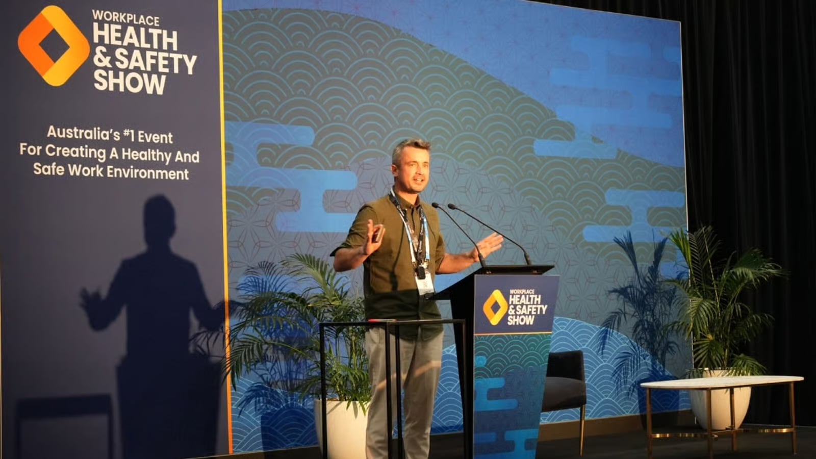 Trav Heaven speaking on stage at the Workplace Health & Safety Show